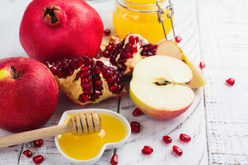 Apple, honey and pomegranate on white wooden background. Jewish New Year - Rosh Hashana concept. Space for text
