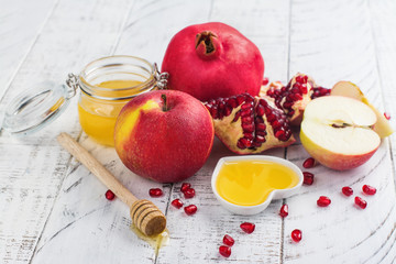 Apple, honey and pomegranate on white wooden background. Jewish New Year - Rosh Hashana concept. Space for text