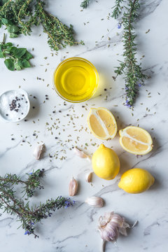 ingredients for a greek flavoured marinade, including lemon, olive oil, rosemary, oregano, thyme, garlic, fennel, salt and pepper