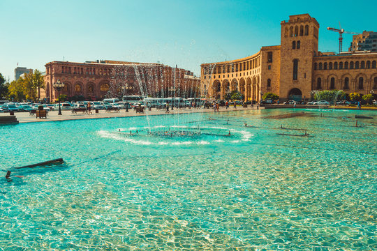 Fountains and architectural complex on Republic Square. Touristic architecture landmark. Sightseeing in Yerevan. City tour. Government House. Travel and tourism concept. Sunny autumn day. Copy space