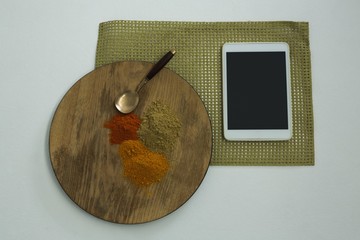 Various type of spices on wooden board with digital tablet