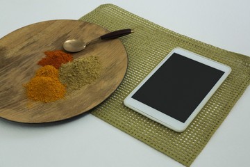 Various type of spices on wooden board with digital tablet