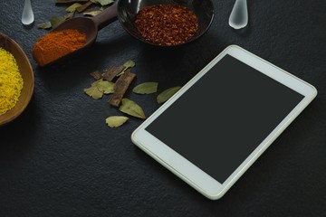 Spices powder with digital tablet on table