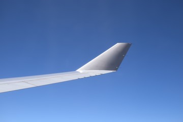 Fototapeta na wymiar Flügelspitze eines Flugzeugs beim Flug über den Wolken