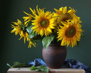 Bouquet of sunflowers in a clay jug.