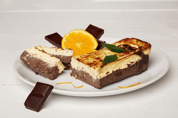 Sweat cake with orange and chocolate on plate on wooden background