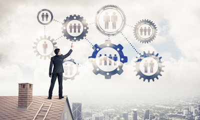 Businessman on house roof presenting teamwork and connection con