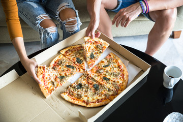Couple at home having pizza for dinner
