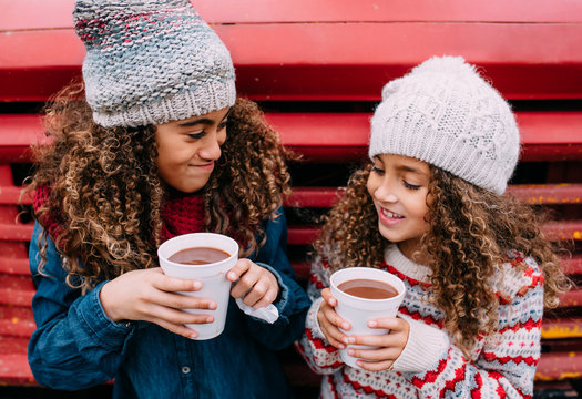 Portrait of sisters with hot chocolate