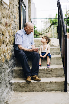 Grandfather with grandson sitting on stairs