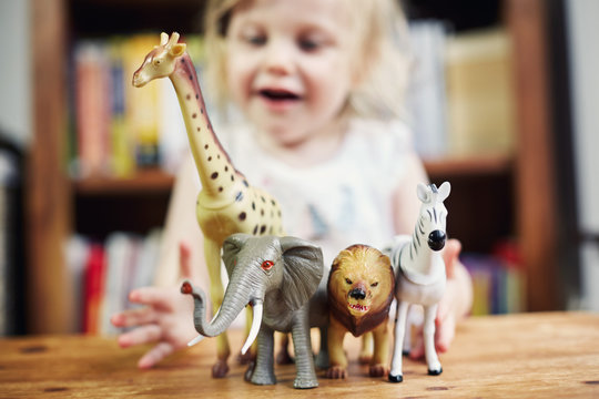 Child playing with toy animals