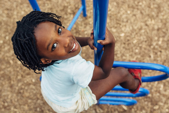 African American Child Climbing At A Playground