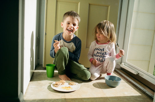 children eating breakfast by door