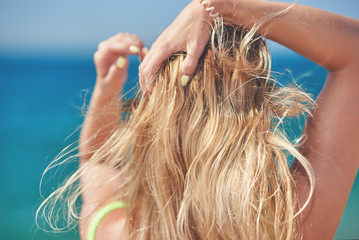 Obraz premium Portrait of a young woman against the sea. Back view.