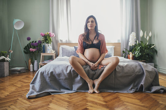 Pregnant Woman Sitting on the Bed in Her Bedroom