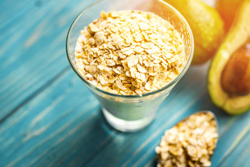 Healthy food. Dietary breakfast or snack. Green smoothies from yoghurt, avocado, oatmeal. On blue wooden table, with ingredients. Selective focus