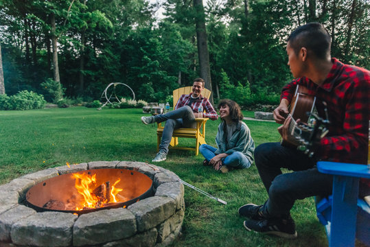 Friends roasting marshmallows around the campfire