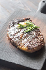 Beef steak with fresh rosemary on the wooden board