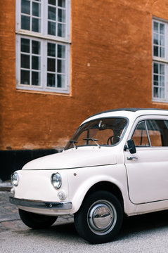 Old car parked in front of house wall
