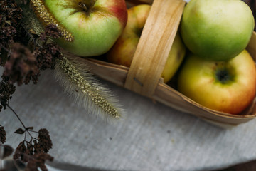 Fresh apples in a wicker basket on a table, selective focus, top view