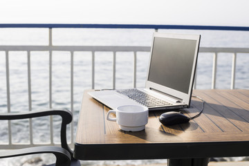 workplace on the beach. computer with a black screen on the desk