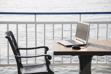 workplace on the beach. computer with a black screen on the desk