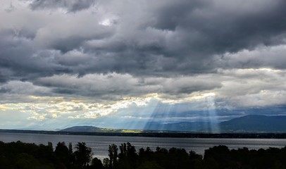 storm sun light rays clouds dramatic lake geneva