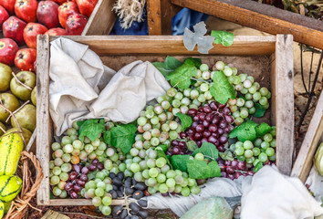 Group of purple and green grapes next to other fruits