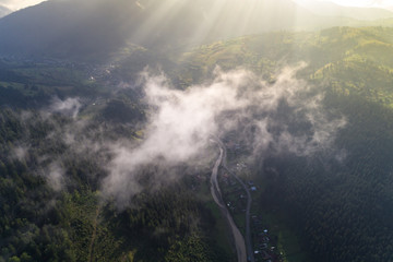 Aerial view of the village in the Carpathian mountains with clouds in the foreground