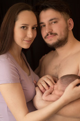 newborn baby mom daddy hands on family