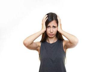 Girl emotions. White background. Portrait of young angry shocked woman holding head
