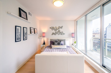 Modern bright bedroom interior with designer pillows in a luxury house.