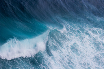 Große Welle mit Gischt in blauem Wasser
