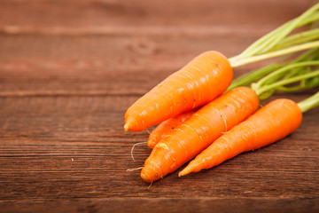 Fresh carrots on a wooden table. Close-up. Vegetables. Space for text.