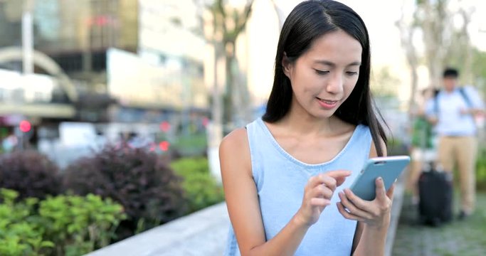 Woman working on smart phone in city