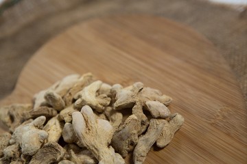 Dried gingers on wooden board over burlap