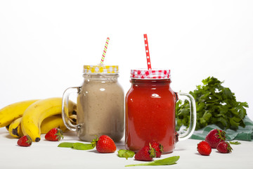 Assortment of fruit and vegetable smoothies in glass bottles with straws