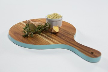 High angle view of rosemary and ginger on wooden serving board