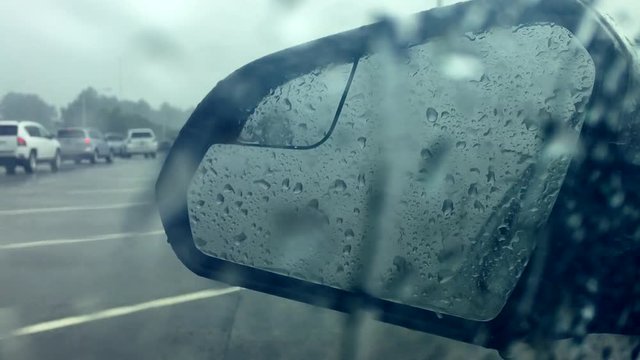 Raindrops fall against the car window with traffic in the wing mirror during the evacuation on a Florida highway from Hurricane Irma