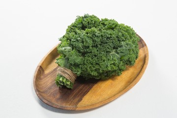 High angle view of fresh kale bundle in wooden plate