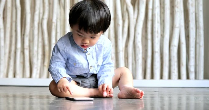 Asian little boy watching on cellphone