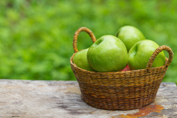 red and green apples with flowers on wooden