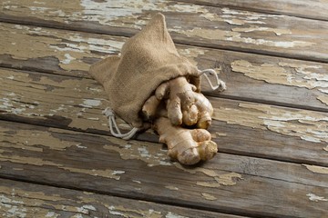 High angle view of burlap and fresh gingers on weathered table