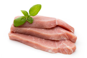Fresh pork fillet with basil on a white background.