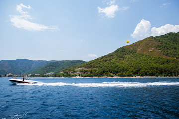 Fototapeta na wymiar Parasailing on the sea from fast motor boat