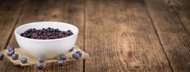 Blueberries (preserved) on wooden background; selective focus
