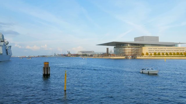 small boat is floating on Oresund strait near Copenhagen Opera House in sunny autumn day