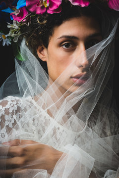 Portrait of teenage boy in veil and flowers crown