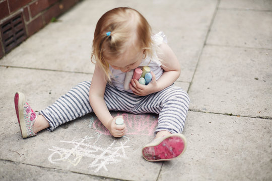 Child drawing with chalk on the floor
