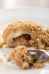 Closeup macro of plum dumplings on the plate with metal fork